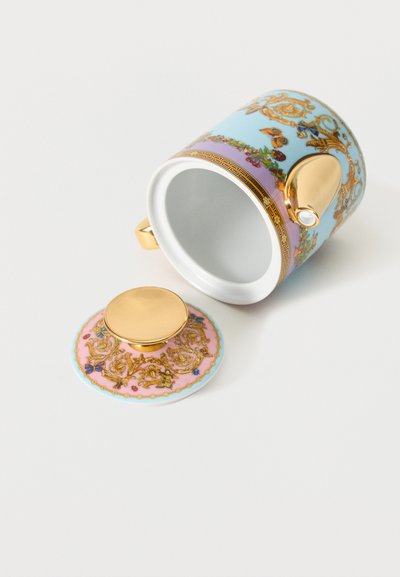 Διακοσμητική πορσελάνινη κούπα τσαγιού με χρυσή λαβή και καπάκι, με παστέλ μπλε και ροζ λουλουδένια και πεταλούδες μοτίβα, ξαπλωμένη στο πλάι.