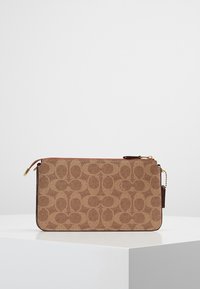 Brązowa kopertówka w wzory z teksturowaną powierzchnią, złotym suwakiem i akcentem łańcucha. Prostokątna forma z skórzanym wykończeniem.