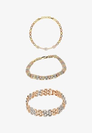 Trzy bransoletki: złota, srebrna i różowe złoto, każda z unikalnym wzorem ogniw łańcucha i dekoracyjnymi elementami na białym tle.