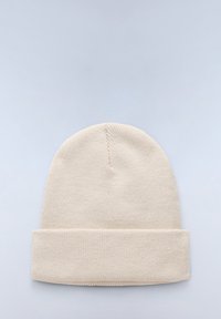 Berretto lavorato a maglia beige con una vestibilità aderente, dotato di un risvolto e di un motivo testurizzato. Realizzato in un tessuto morbido e caldo per garantire comfort.
