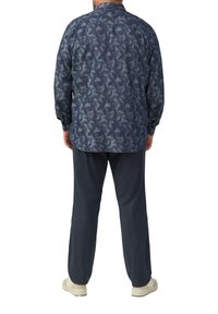 Blauw patroon langemouwen overhemd met een zachte textuur, gecombineerd met donkere, losse broek en casual beige schoenen.