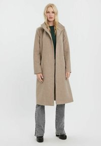 Beige vlněný kabát se strukturovaným límcem, dlouhými rukávy a délky do půli stehen. Disponuje čistým designem a jemnou texturou.