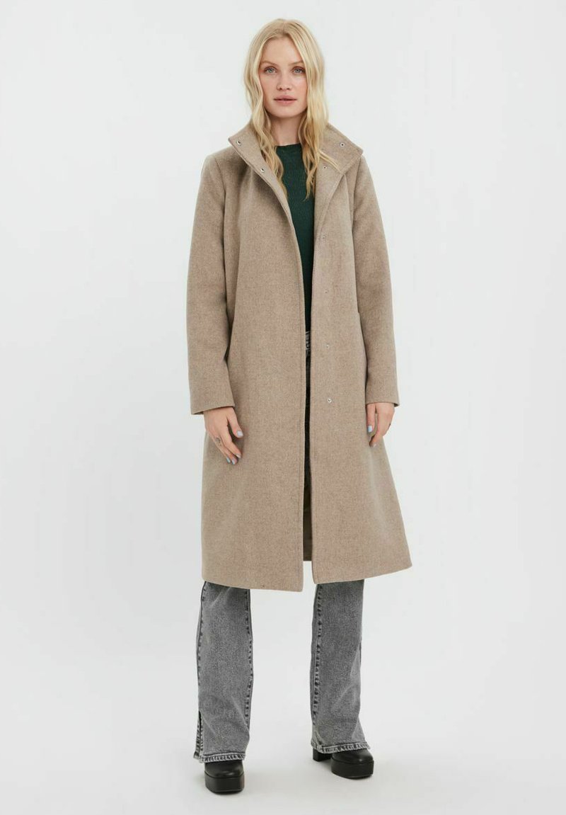 Beige vlněný kabát se strukturovaným límcem, dlouhými rukávy a délky do půli stehen. Disponuje čistým designem a jemnou texturou.