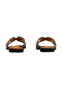 Braune Ledersandalen mit offenem Rücken, Ausschnittdesign und flachen schwarzen Sohlen. Das Innere hat glatte, beige Lederdetails.