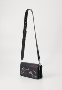 Sac bandoulière en cuir noir, ornée de motifs brodés colorés, avec une bandoulière réglable et des accents en métal argenté. Forme rectangulaire avec une texture lisse.