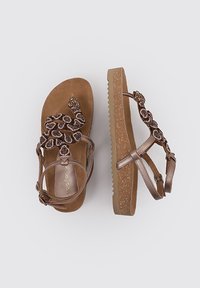 Sandales marron avec des brides décoratives en perles, une semelle intérieure en liège texturée et une semelle extérieure légère et crantée, dotées d'une bride de cheville réglable.