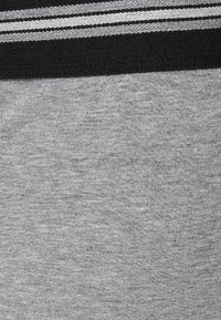 Grått tyg med en slät textur, med ett kontrasterande svart band prytt med två tunna grå ränder.