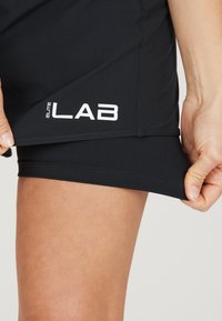 Zwarte sportshorts met een gladde textuur, voorzien van de tekst "ELITE LAB" in het wit op de onderste zijkant, met een strakke pasvorm.