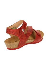 Red leather wedge sandal with two adjustable straps, cork footbed, textured texture, and rubber sole for traction.