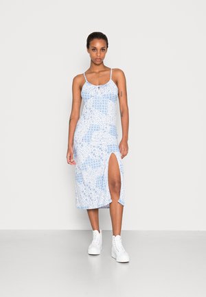 Vestido midi azul com padrão, alças finas e fenda lateral. Feito de tecido leve, apresenta um detalhe de laço na gola.