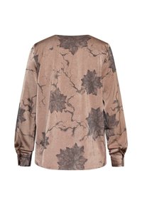 Langærmet top i dæmpet pink med en tekstureret overflade, der har et sort blomstermønster og subtile årer gennem stoffet.