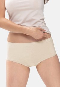 Culotte hipster en mélange de coton beige avec une texture lisse et une taille élastique. Présente des coutures minimales et un design à coupe classique.
