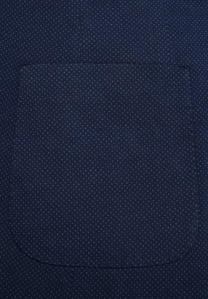 Granatowy materiał z subtelnym wzorem diamentowym; posiada zakrzywioną kieszeń z przeszytymi brzegami, tworzącą teksturowany wzór.