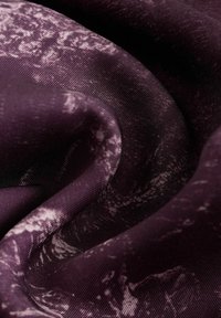 Lilla tekstureret stof med marmoreret mønster. Materialet har en glat finish og viser lyse og mørke variationer på overfladen.
