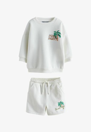 Bluză albă cu inscripția „Pool Party” și grafică cu palmier, asortată cu pantaloni scurți albi cu palmier și textul „sunset life”.