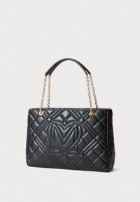 Gestepptes schwarzes Lederhandtasche mit goldenen Kettenakzenten und einem oberen Griff. Enthält ein erhabenes "M"-Logo auf der Vorderseite. Rechteckige Form.