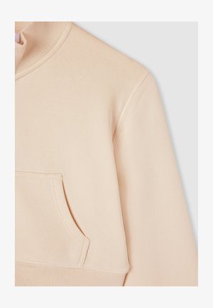 Felpa beige chiaro con collo alto, polsini a costine e tasca laterale. Tessuto morbido con texture liscia e dettagli di cucitura discreti.