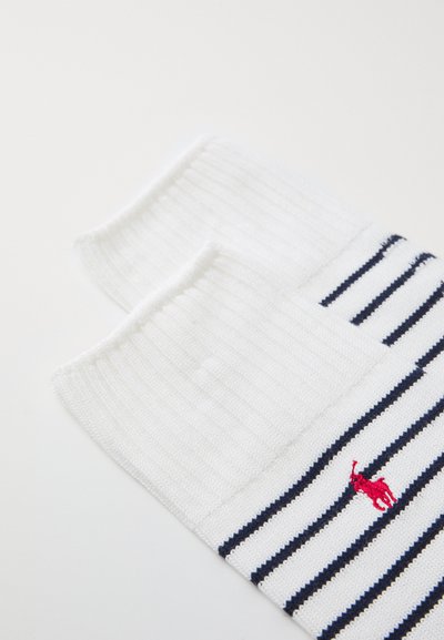 Weiße und marineblaue gestreifte Socken mit gerippten Bündchen, die ein kleines rotes Logo eines Pferdes im Knöchelbereich zeigen. Aus einem weichen Baumwollmischgewebe.