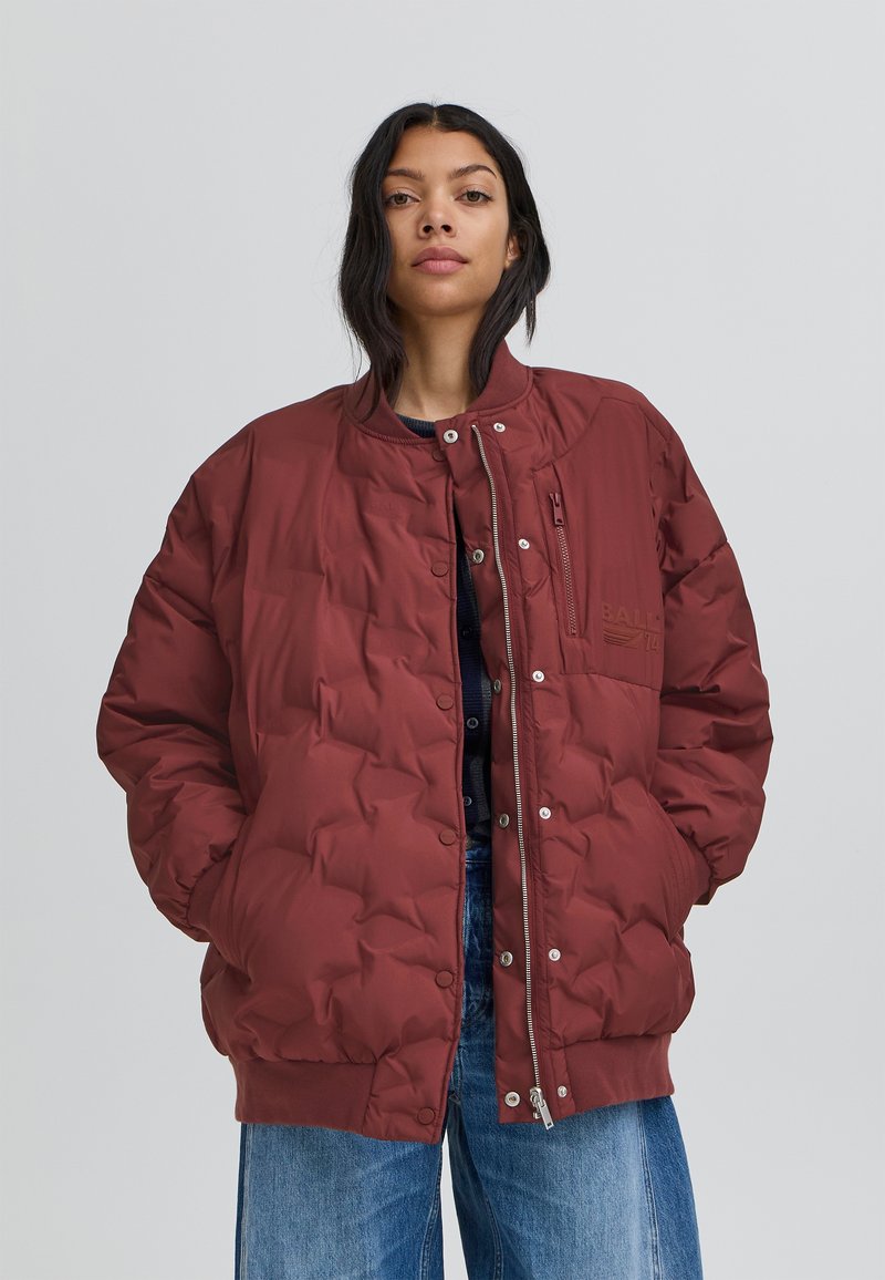 Burgundijas pūkainā jaka ar kvadrātveida dizainu, ar spiedpogu priekšpusi, ribinātu apakšmalu, rāvējslēdzēja kabatu un logotipa detaļām uz krūtīm.