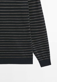 Zwarte trui met lange mouwen van gebreide stof, voorzien van smalle witte horizontale strepen en geribbelde boorden en zoom, op een witte achtergrond.