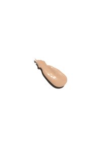 Beige flytande foundation med en slät, blank yta, formad som en tår, vilande på en vit bakgrund.