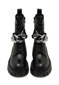 Černé kožené kotníkové boty s masivní podrážkou, šněrováním, bočními zipy a stříbrným řetízkem kolem vršku.