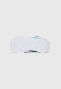 Suola di sneaker bianca con un motivo a cuore, con una textura liscia e una parte superiore colorata e multicolore visibile vicino al tallone.