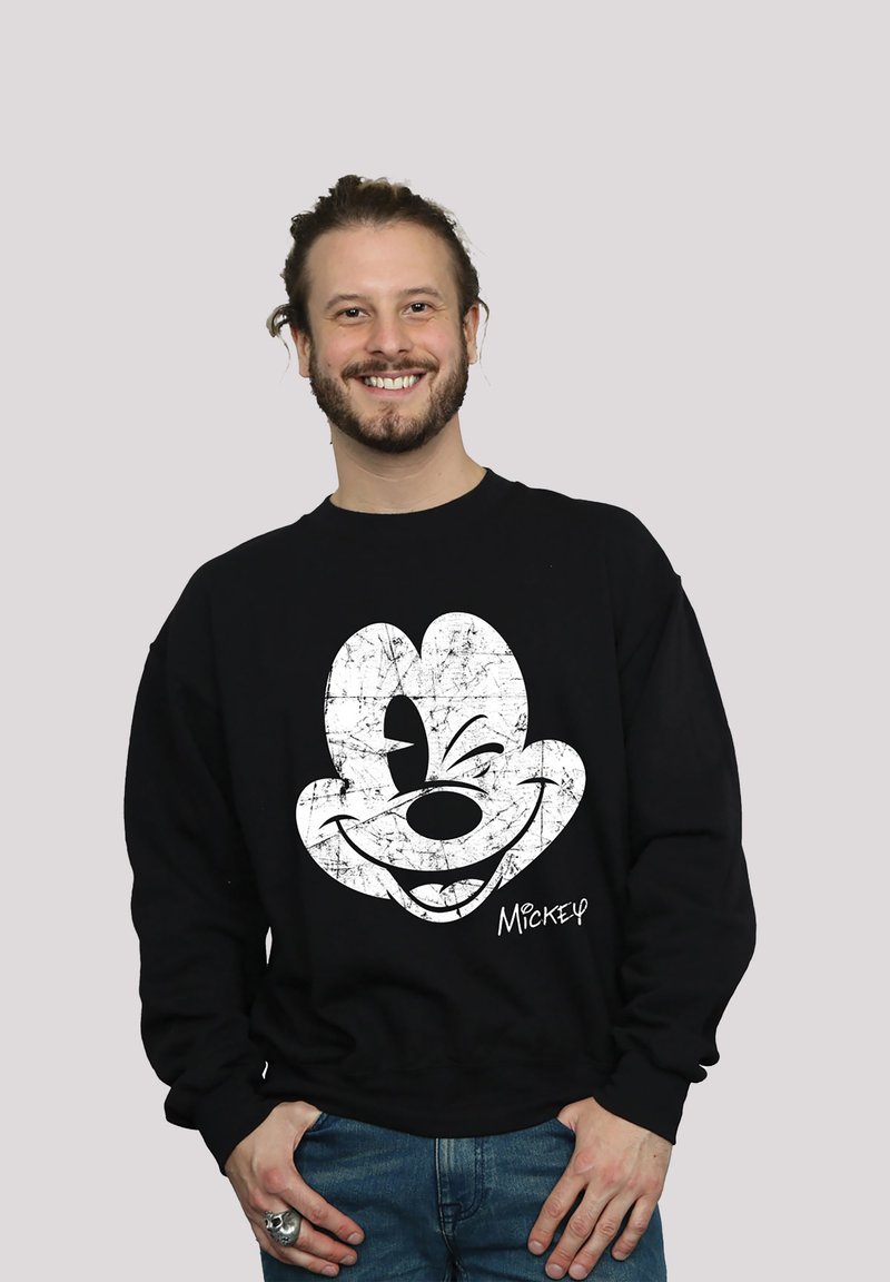 Svart hettegenser med et slitt hvitt Mickey Mouse-motiv på forsiden, rund hals og lange ermer.