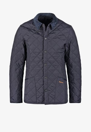 Veste matelassée bleu marine avec un col en velours côtelé, des boutons-pression, deux poches avant et un petit logo orange sur la poche gauche.