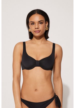 Top bikini nero con spalline larghe e un dettaglio centrale arricciato, abbinato a un fondo coordinato con un laccio laterale. Texture liscia.