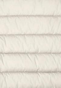 Tessuto beige chiaro trapuntato con linee di cucitura orizzontali a imbottitura distanziate uniformemente sulla superficie.