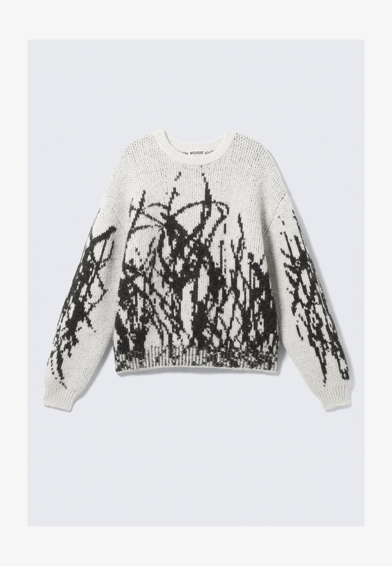 Pull-over en tricot de couleur blanche avec motif graphique noir. Il présente un col rond, des manches longues et un ourlet côtelé. Texture douce.
