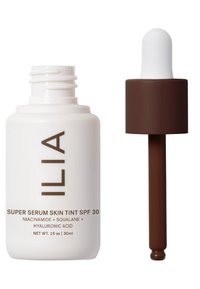 ILIA Super Serum Skin Tint SPF 30 i en vit flaska med brun text, har en pipettkork och rymmer 30 ml.