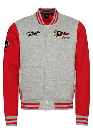 Giacca varsity grigia e rossa con polsini e colletto a righe, bottoni a pressione frontali, scritta Harajuku Hawks e toppe ricamate con bandierina e logo.