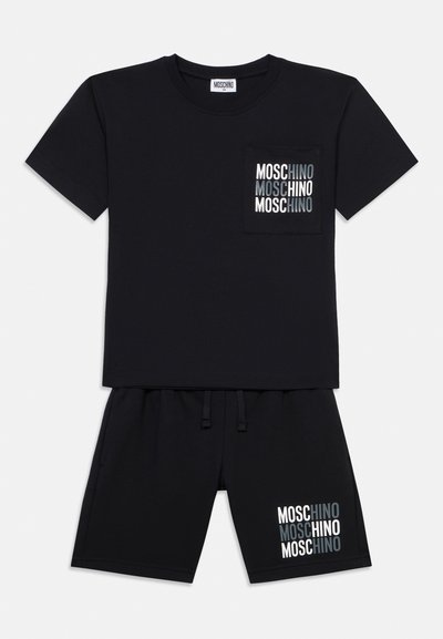 Fekete rövid ujjú póló és rövidnadrág szett, fehér és szürke "MOSCHINO" logó ismétlődő mintájával a mellkasi zsebén és a bal lábszáron.
