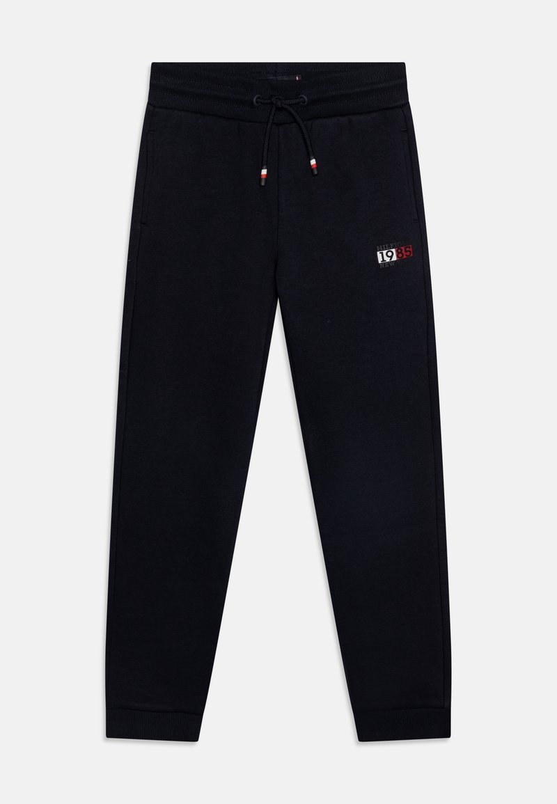 Černé tepláky vyrobené z měkkého materiálu, s elastickým pasem a šňůrkou na stažení, bočními kapsami a malým grafickým logem na stehně.