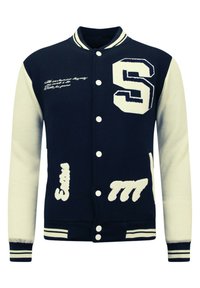 Marineblauwe varsityjack met crèmekleurige mouwen, voorzien van een geborduurde "S" en witte letters. Knopsluiting aan de voorkant en gestreepte ribgebreide boorden.