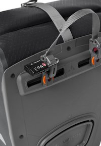 Grijze harde koffer met een gestructureerd oppervlak, combinatieslot, verstelbare riemen en oranje accenten. Voorzien van twee clipsluitingen.