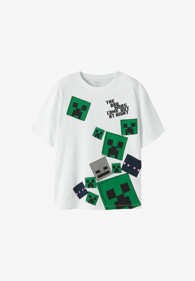T-shirt blanc avec des visages de monstres pixellisés verts, gris et noirs et le texte "The bad mobs come out at night" en lettres capitales.