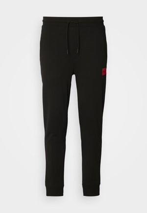 Schwarze Sweatpants aus weichem Stoff, mit einem Kordelzugbund, schmaler Passform und einem rotenLOGO-Patch am linken Oberschenkel.