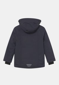 Granatowa wodoodporna kurtka z kapturem, charakteryzująca się gładką fakturą, długimi rękawami i odblaskowymi paskami na dolnej części pleców.