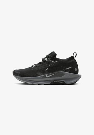 Mustad ja hallid matkajooksujalatsid, millel on tekstuuriga pealne, peegeldavad aktsendid ja pehme sisetald, millel on "Nike Trail ATC" logo.