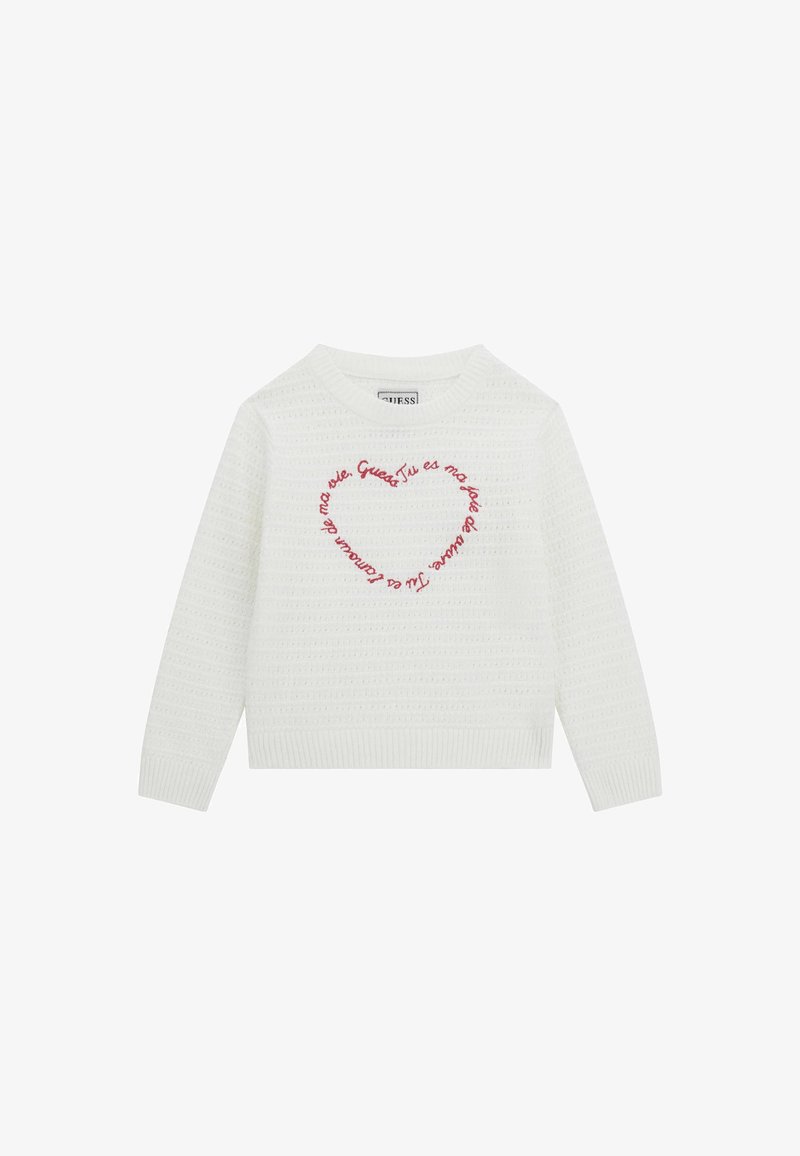 Valge kootud sviiter, millel on tekstuuriline muster ja punane tikand süda kujundusega, mille keskel on ringikujuline tekst.