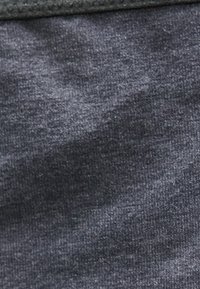 Κοντινή εικόνα σκουρόχρωμου γκρι πλεκτού υφάσματος με ορατή υφή και λεπτή ραφή.