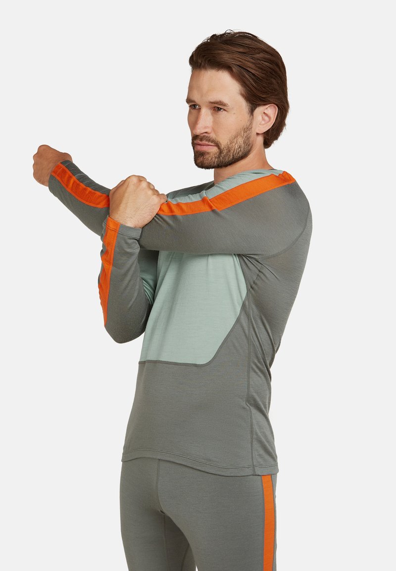 Långärmad träningsskjorta i ljusgrått med orange randade detaljer, med ett lätt och andningsbart tyg och åtsittande design.