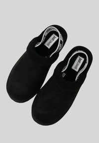 Zoccoli neri con esterno in morbido camoscio liscio, punte arrotondate e collo morbido e strutturato. Etichetta interna recante la scritta "justcare."