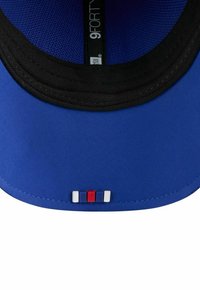 Blaues Baseballcap mit schwarzem Innenfutter, das auf der Unterseite des Schirms mit einem kleinen Patch aus rot, weiß und blau gestreift ist.