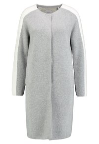 Vestido de punto gris con acentos blancos en los hombros, escote en V, mangas largas y corte recto. Textura suave, diseño sencillo, hasta la rodilla.