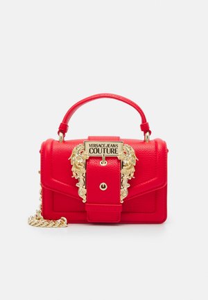 Pieni punainen nahkalaukku yläkahvalla, kultainen ketjuhihna ja koristeellinen kultainen solki, jossa lukee "Versace Jeans Couture".