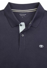 Navyblauwe polo shirt van Tom Tailor met een lichtblauwe kraag, een knoopsluiting met twee knopen en geborduurd logo op de borst. Regular fit.